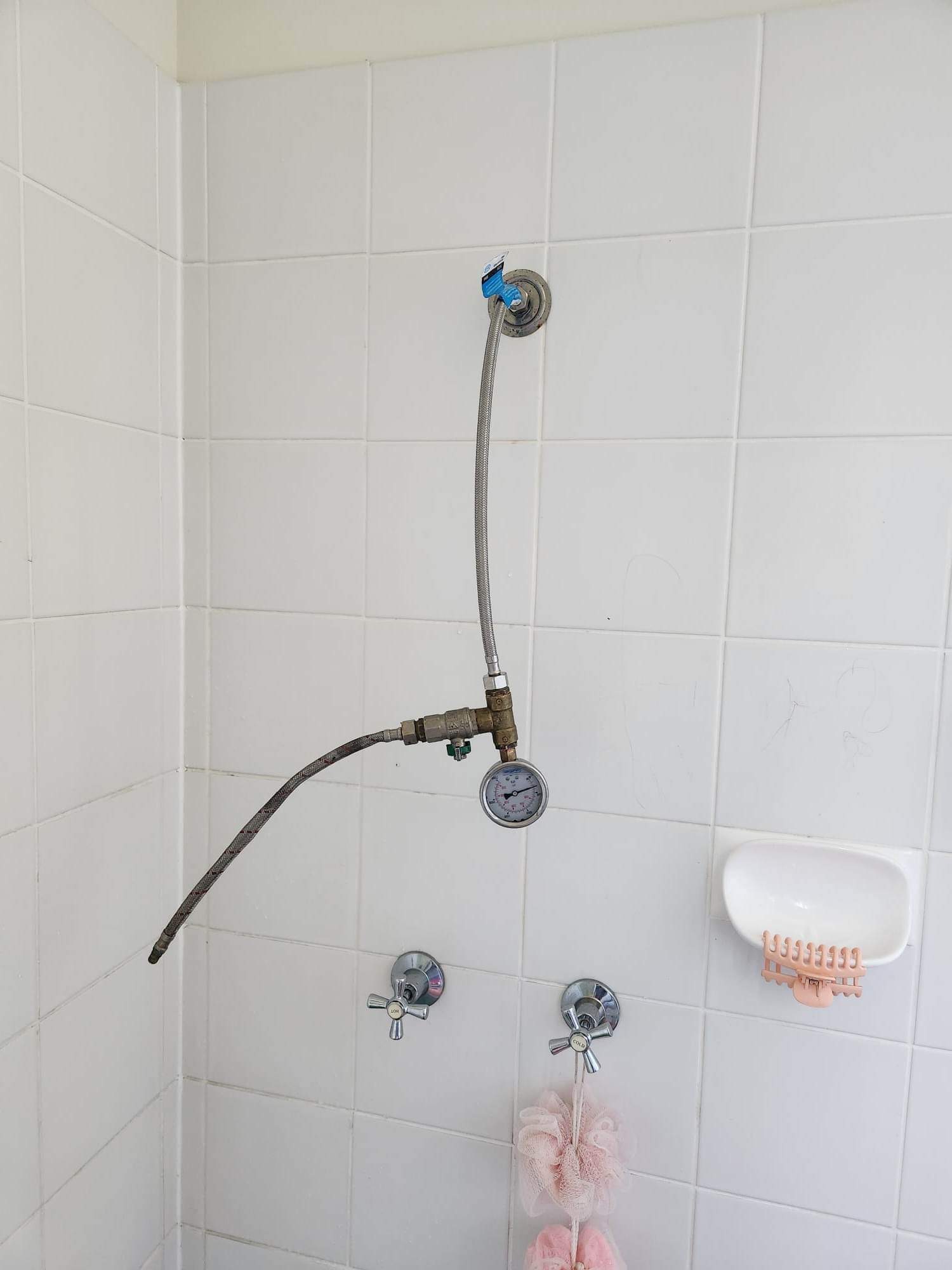 Pressure-reducing valve and gauge fitted above shower taps